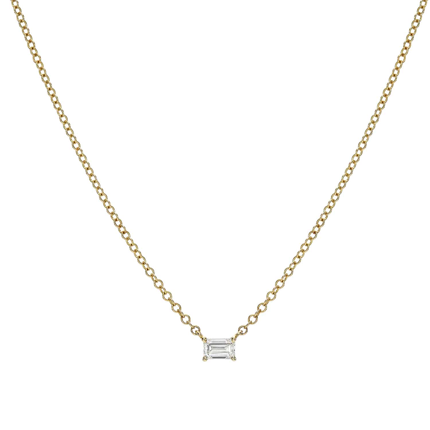 Explore the elegance of Janet Heller Fine Jewelry with the Solitaire Emerald Cut Diamond Necklace. Featuring a minimalist gold chain and a small rectangular diamond, it shines brilliantly on a white background, exuding timeless sophistication.