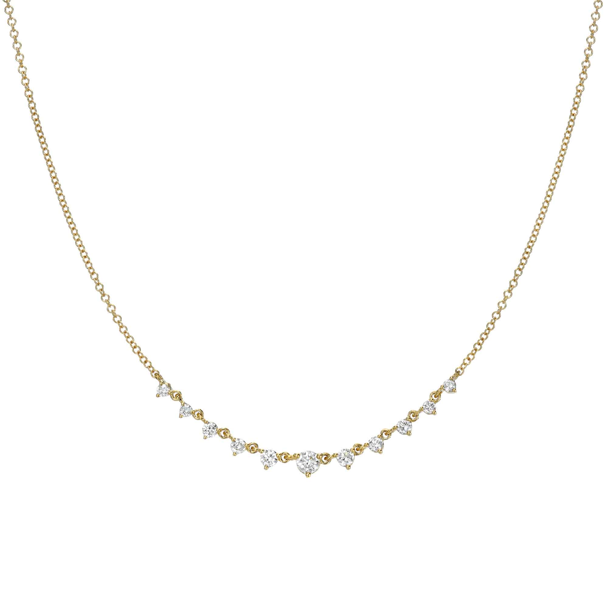 The Curved Round Diamond Necklace is a delicate gold piece with sparkling diamonds arranged centrally in an elegant curve. Its simple, thin chain enhances its sophistication. For customizations or inquiries, please contact us.