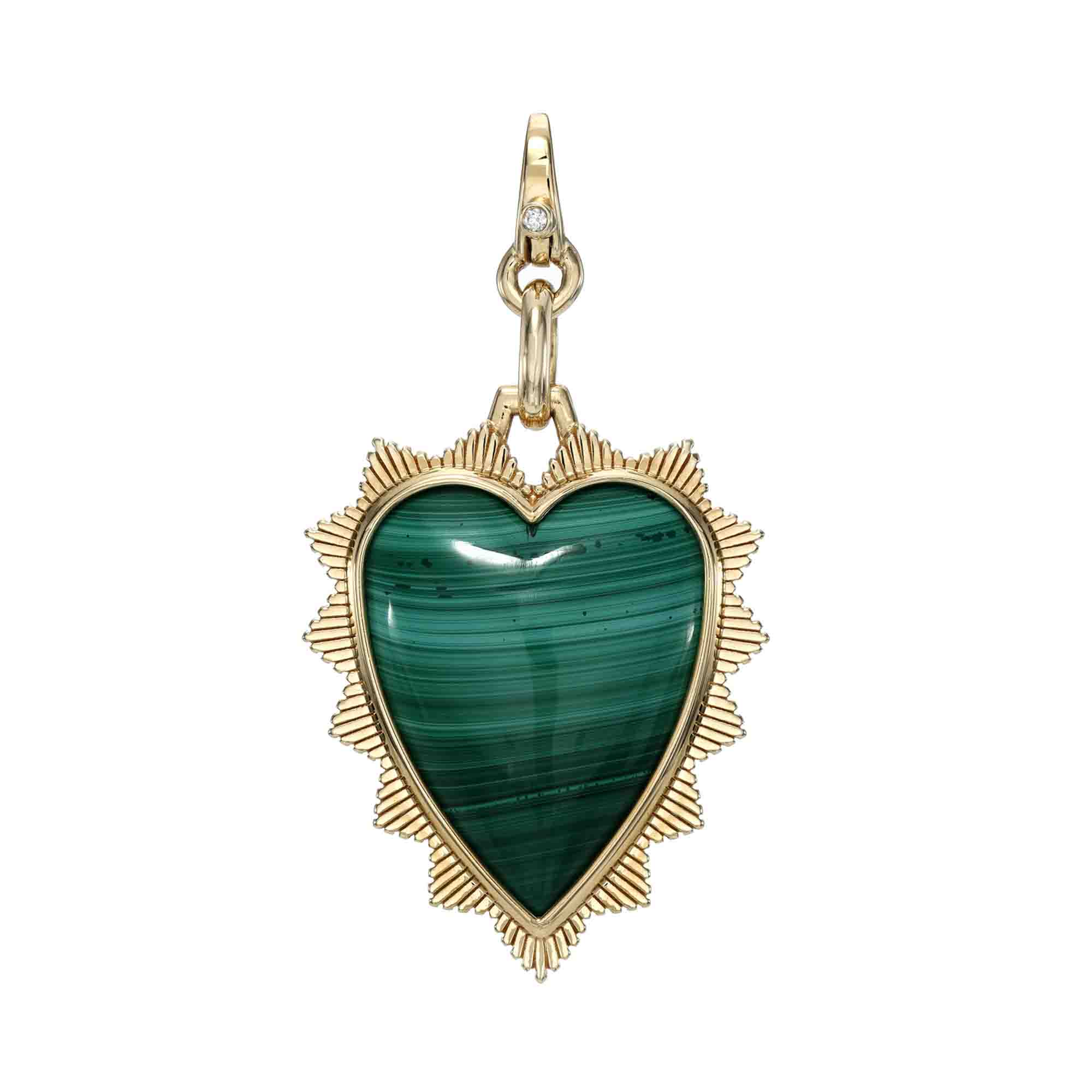The Malachite Heart Shield Charm from Janet Heller Fine Jewelry features a heart-shaped green malachite stone with textured gold edging and an ornate loop, showcasing its natural striations and sunburst-like points for bespoke customization.