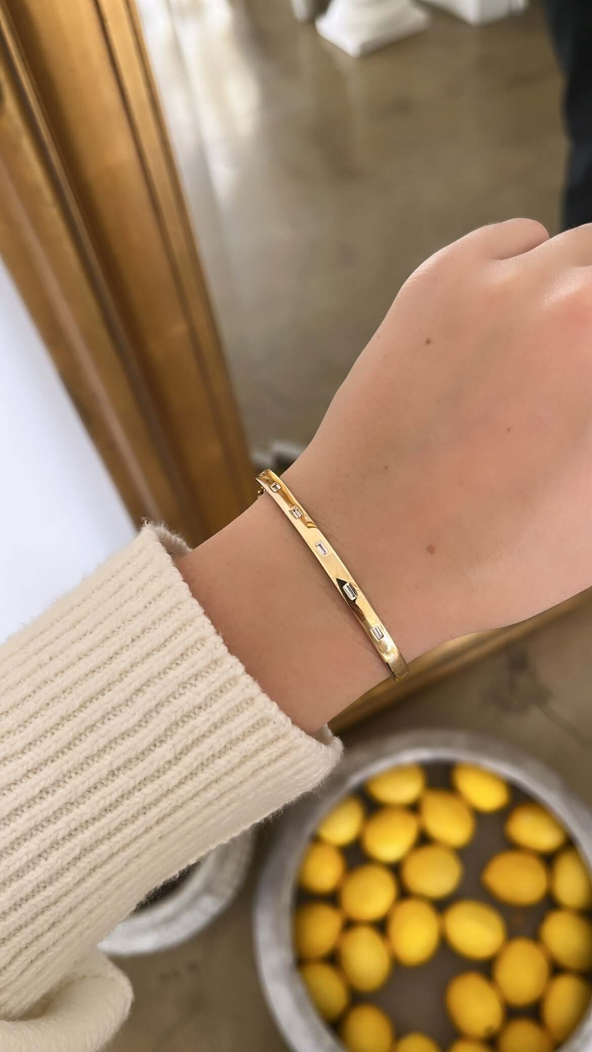 The Baguette Diamond Bangle from Janet Heller Fine Jewelry is crafted in 14KT gold and is embellished with seven baguette diamonds. The bangle can be worn on its own or stacked with other bracelets.