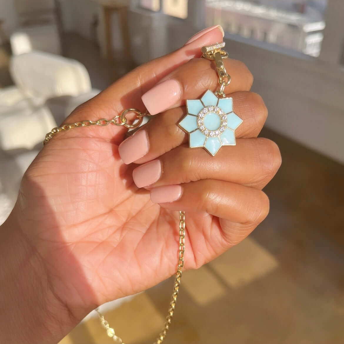 The Enamel & Diamond Flower Charm necklace by Janet Heller Fine Jewelry, features a blue flower pendant with a circular center surrounded by diamonds. The clasp which adorns a single diamond clips easily onto various Janet Heller Fine Jewelry necklaces and chains.