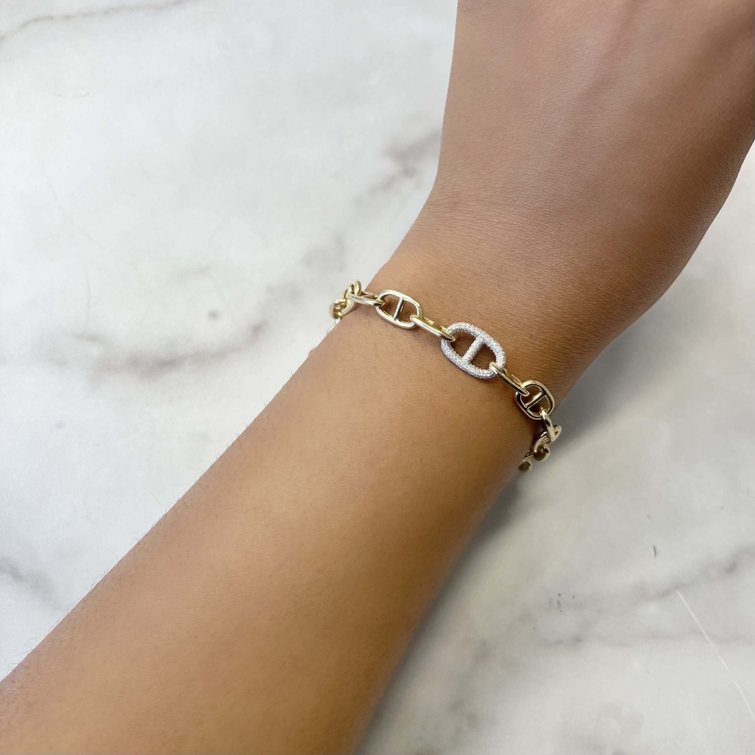 The Diamond Juliette Bracelet features a chain design with a center link embellished with glittering stones. Photographed on white marble, this piece epitomizes the exquisite craftsmanship of janethellerfinejewelry.