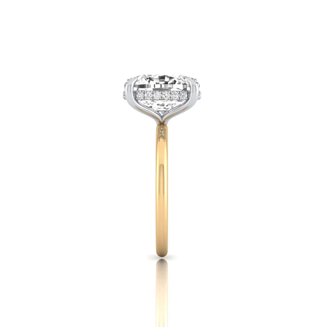 Side view of the Solitaire + Hidden Halo engagement ring with a gold band and silver diamond setting. Surrounding small diamonds enhance brilliance, creating a shimmering reflection on the white surface.
