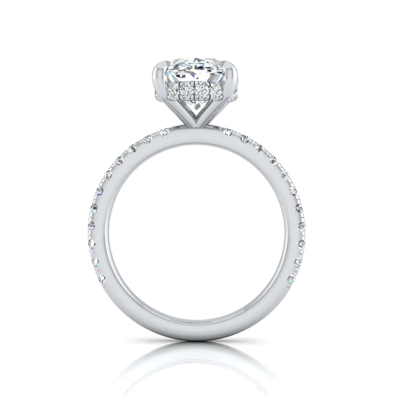 The Unity + Hidden Halo is a striking silver engagement ring featuring a large round diamond surrounded by a dazzling halo design. Its band, adorned with pavé diamonds, enhances the sparkle and sophistication. The ring stands upright against a white background.