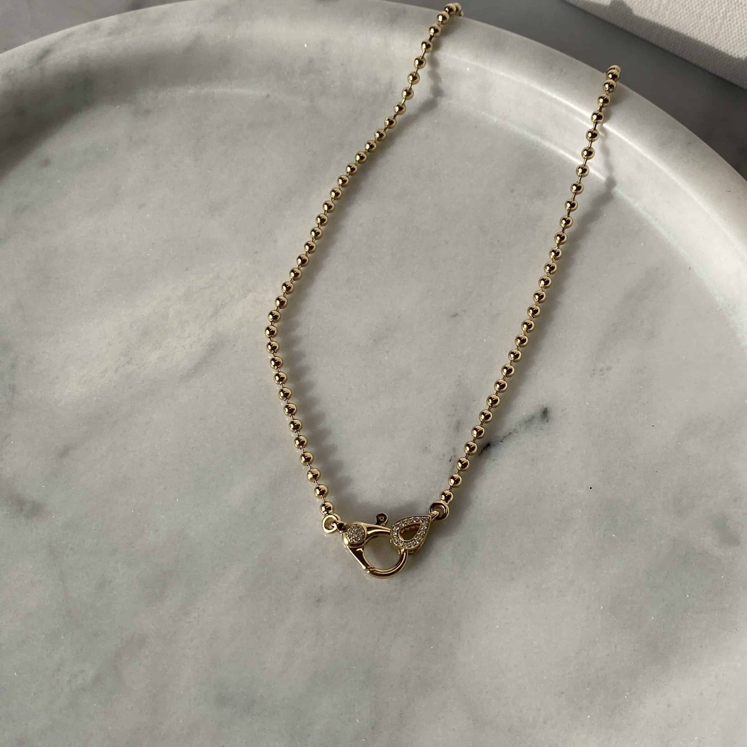 The 3mm Paris Chain from Janet Heller Fine Jewelry is crafted in 14KT gold. The necklace features a beaded chain with a diamond oval pendant and diamond clasp. It's the ideal necklace to showcase a Janet Heller Fine Jewelry charm.