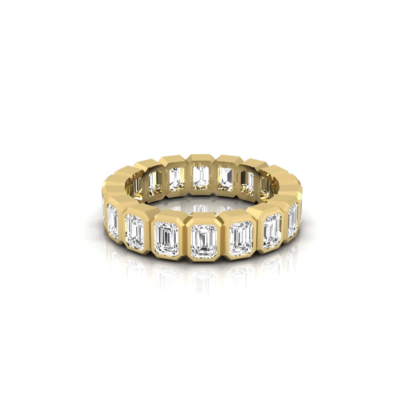 The Bezel Set Emerald Cut Eternity Ring is an 18KT gold band adorned with a continuous circle of rectangular-cut clear gemstones, displayed on a white background.