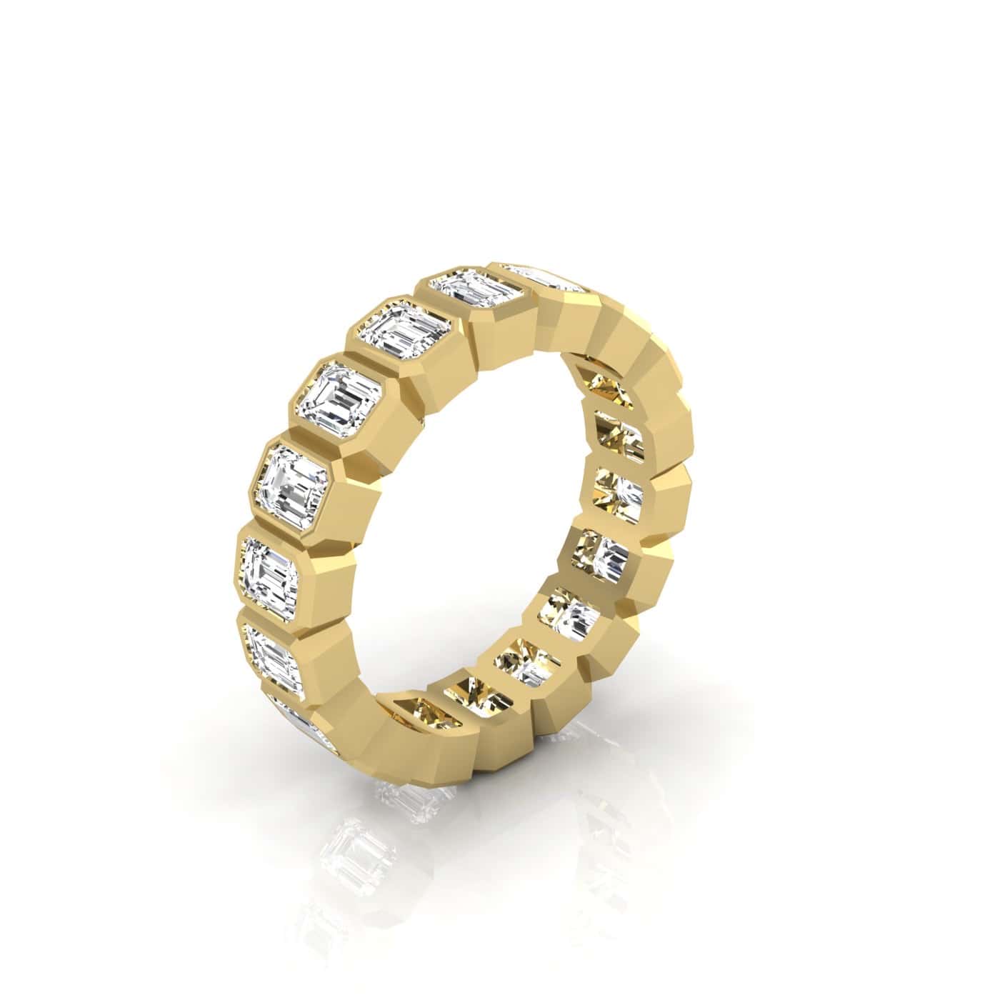 The Bezel Set Emerald Cut Eternity Ring is a custom-made 18KT gold band with a geometric design, featuring evenly spaced VS clarity rectangular emerald-cut gemstones, casting an elegant reflection on a white surface.