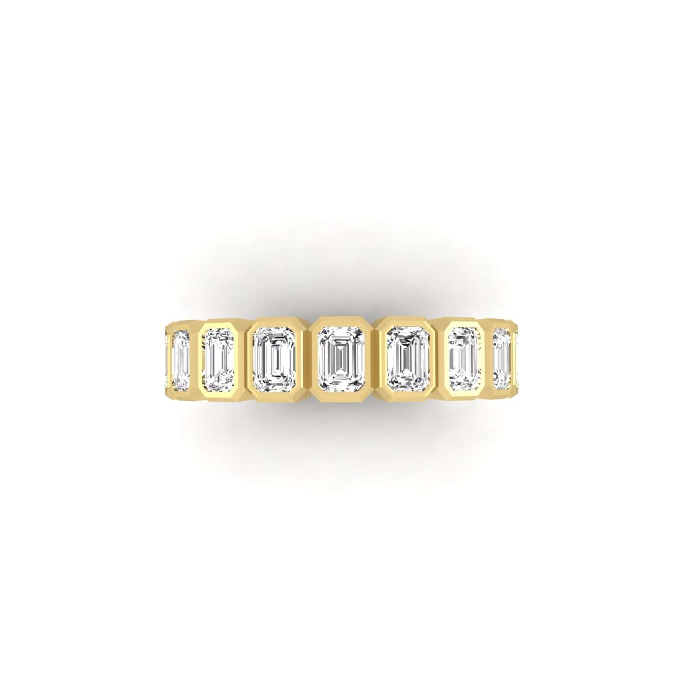 The Bezel Set Emerald Cut Eternity Ring showcases VS Clarity diamonds in a minimalist design, set in thick 18KT gold. The row of emerald-cut gemstones shines brilliantly against a plain white background.