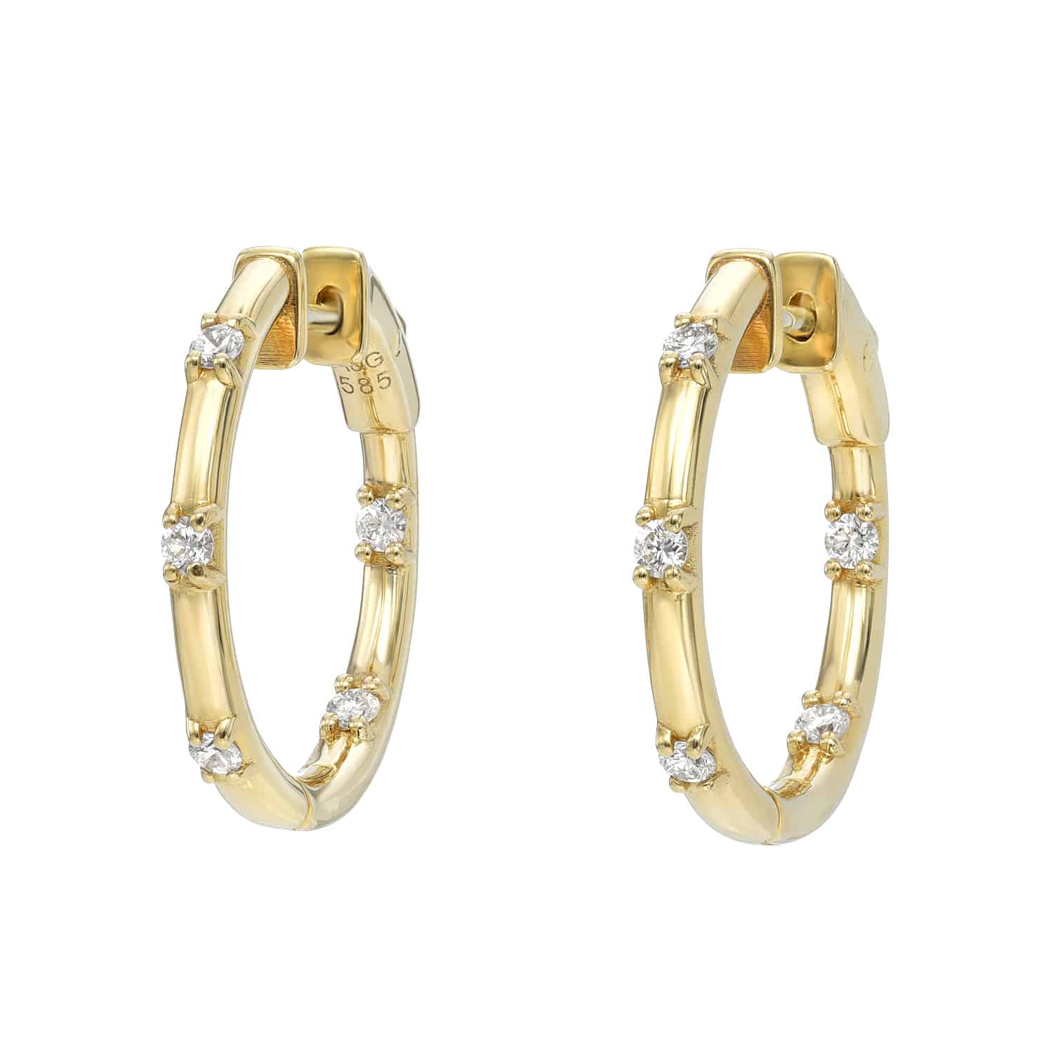 The Diamond In & Out Hoops from Janet Heller Fine Jewelry are crafted in 14KT gold. The earrings are studded with round diamonds. The hoops can be worn alone or layered along the ear with other earrings.