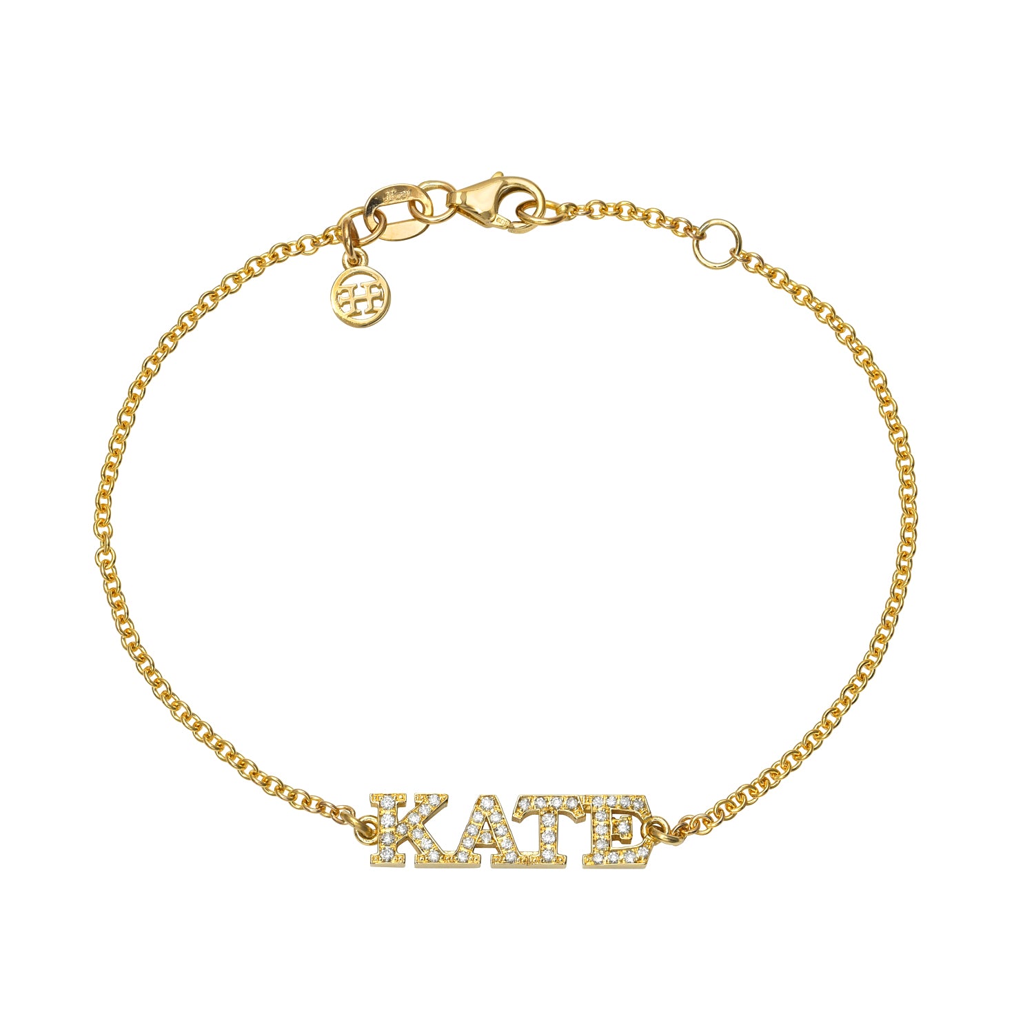 The Diamond Block Name Bracelet is a personalized gold chain bracelet with a clasp and circular charm. The centerpiece features KATE adorned with small white stones, making it a unique piece for special experiences.