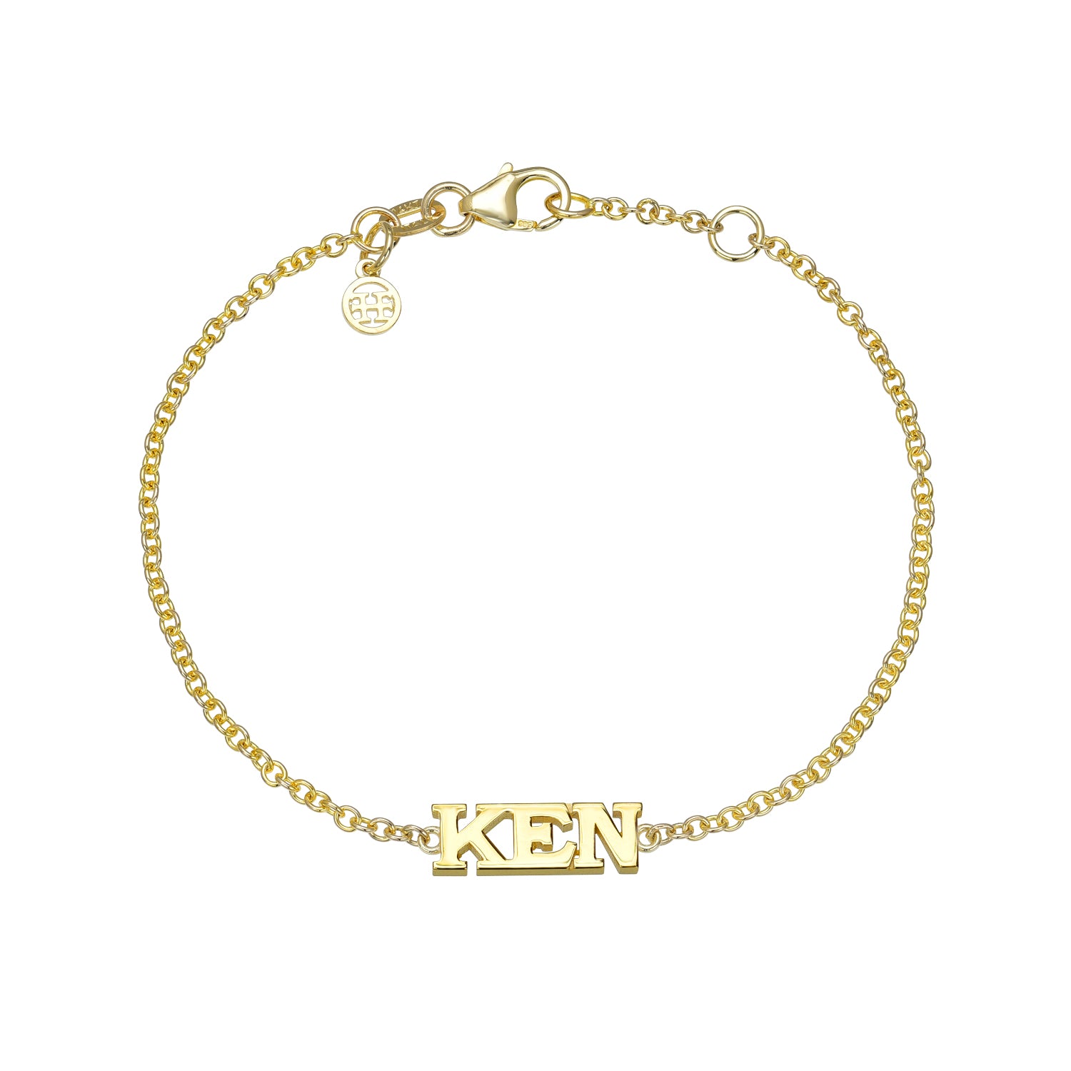The Block Name Bracelet features a gold chain with a lobster clasp, a KEN pendant in capital letters, and a small circular charm near the clasp—ideal for those who value unique style in their personalized jewelry.