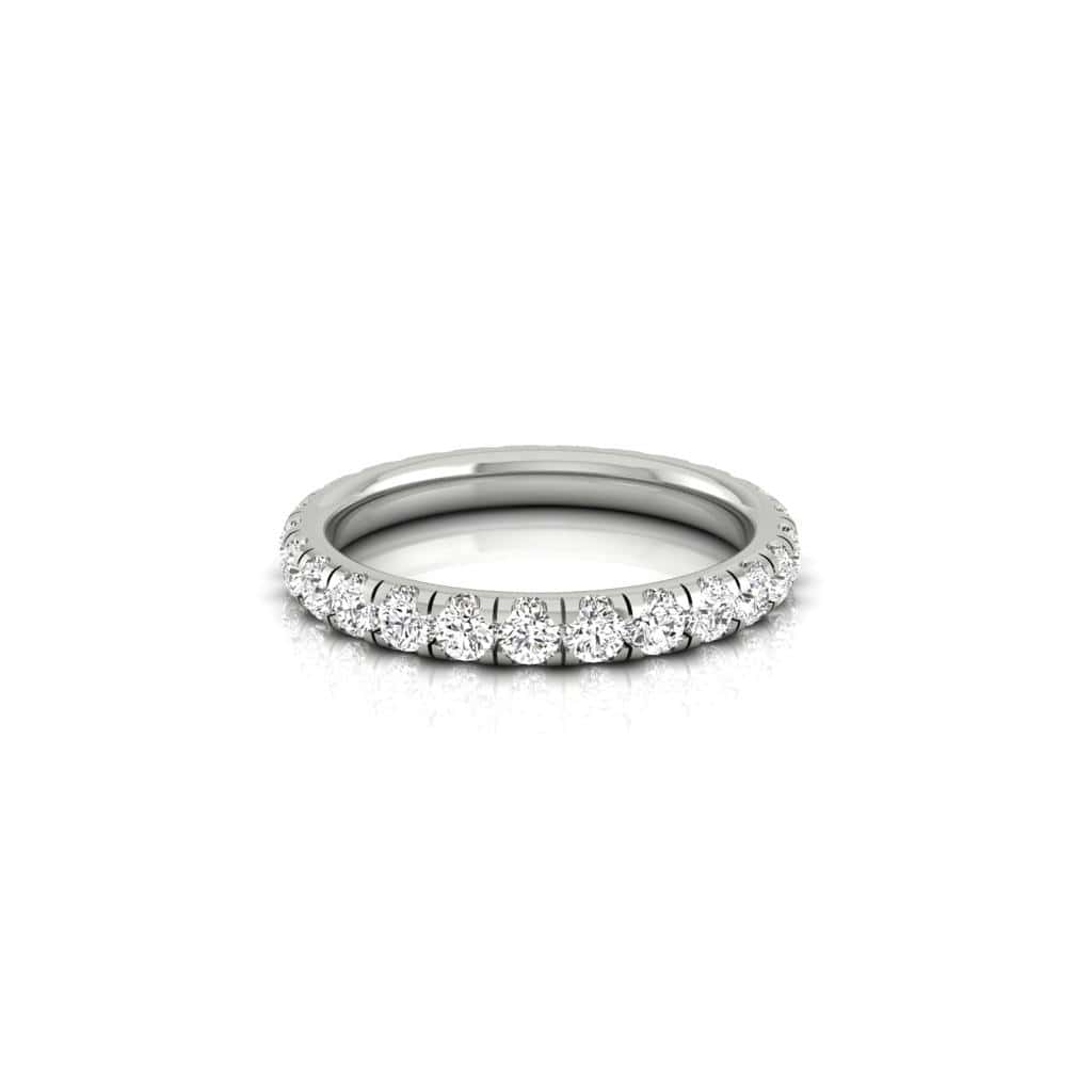 The 1ct Round Diamond Eternity Ring, made of 18KT gold with round diamonds of VS clarity evenly spaced around the band, is placed on a reflective white surface to beautifully enhance the sparkle.