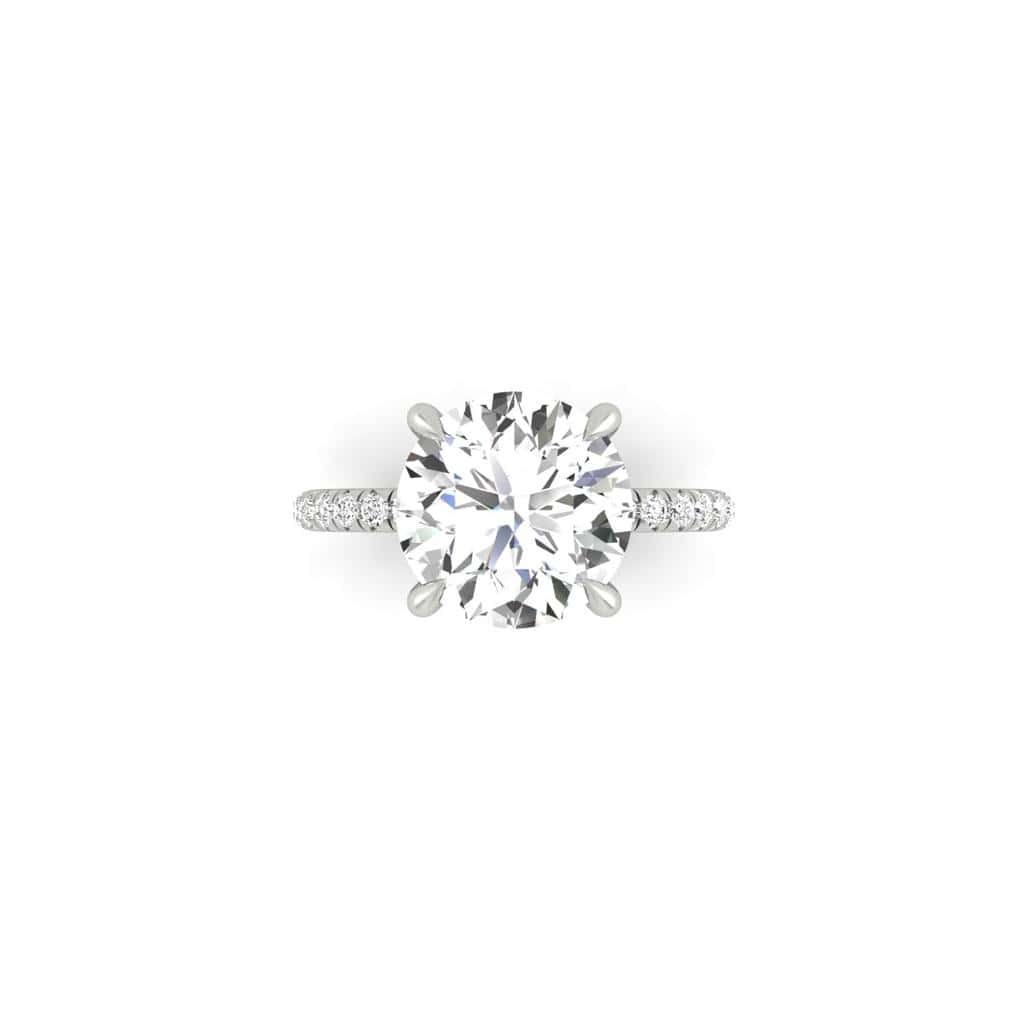 A silver engagement ring showcases a large round-cut diamond centerpiece, complemented by smaller diamonds on a French Pavé set band and enhanced by the elegant Amélie + Hidden Halo.