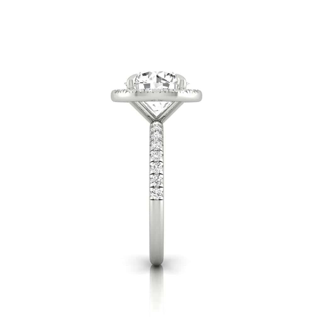 A side view of the Amélie + Full Halo ring features a stunning center diamond with a radiant halo, set in French Pavé for added sparkle, displayed upright against a white backdrop.
