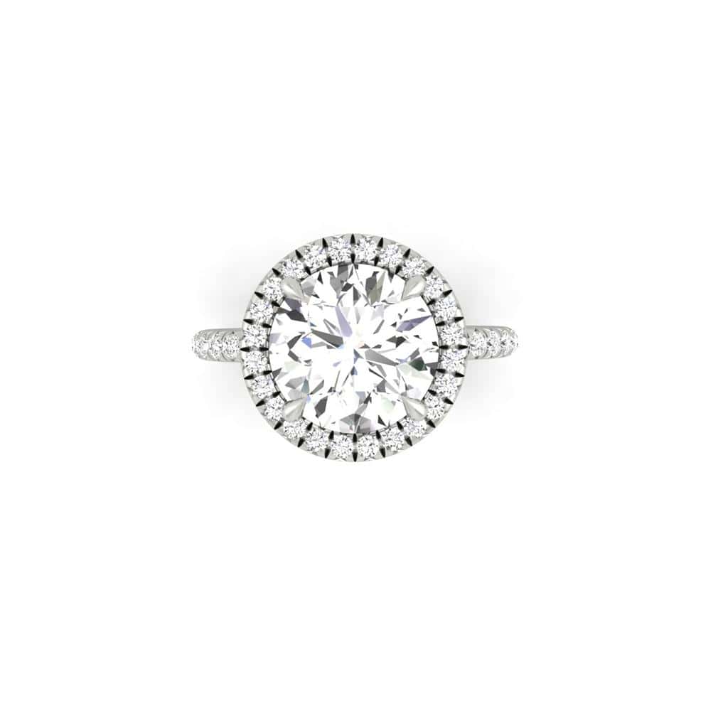 The Amélie + Full Halo engagement ring features a top view of a stunning center diamond, surrounded by a shimmering halo. The French Pavé set band adds extra sparkle with its elegantly placed small diamonds on a simple white background.