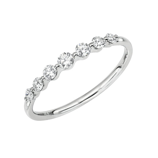 The 7 Diamond Samantha Ring features a delicate 14KT gold band adorned with seven sparkling round diamonds in minimal bezel settings—a timeless piece of fine jewelry.