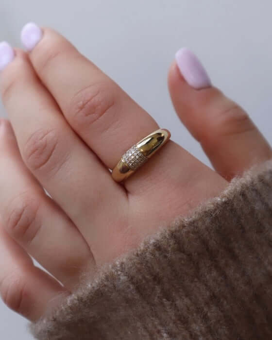 The Diamond Dome Ring from Janet Heller Fine Jewelry is crafted in 14KT gold.  The band features a central section adorned in a sparkling diamond grid pattern. The ring can be stacked or worn on its own.
