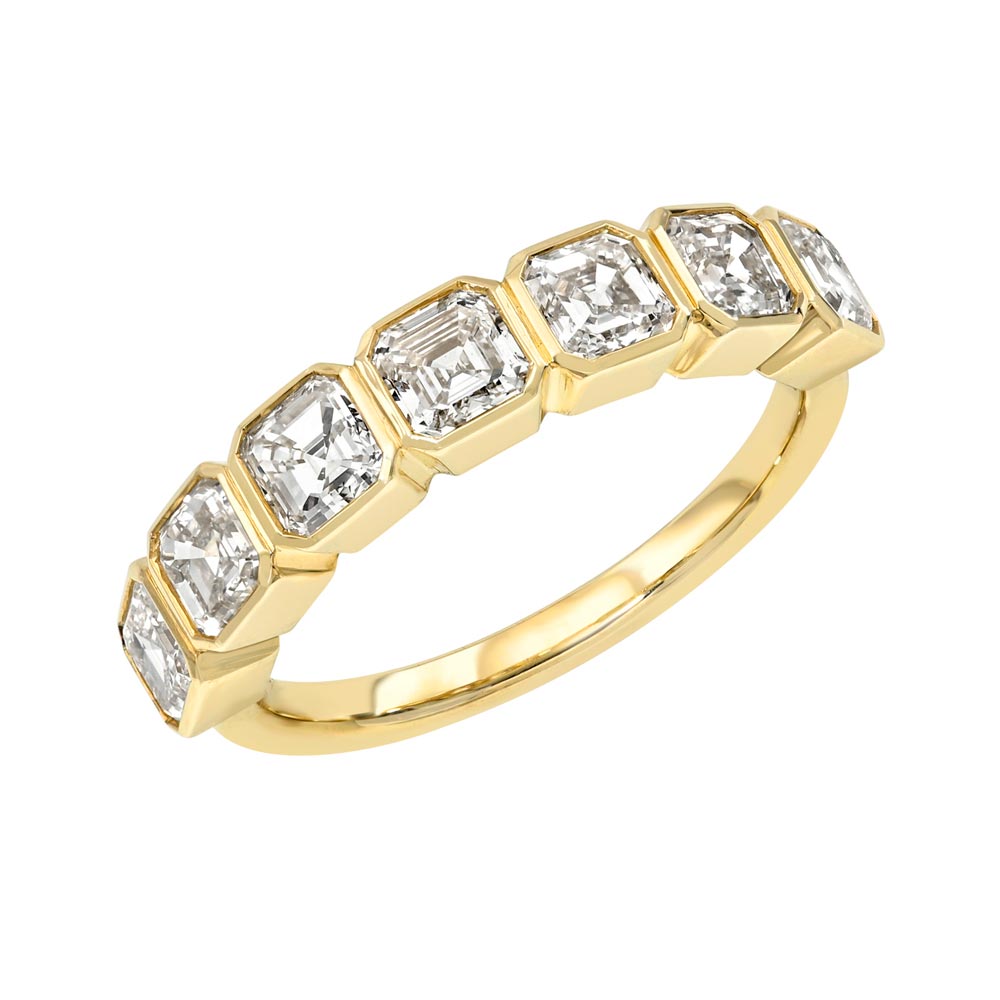 The Half Lab Asscher Diamond Eternity Ring from Janet Heller Fine Jewelry features seven rectangular step-cut diamonds, each set in its own geometric bezel along a 14KT gold band.