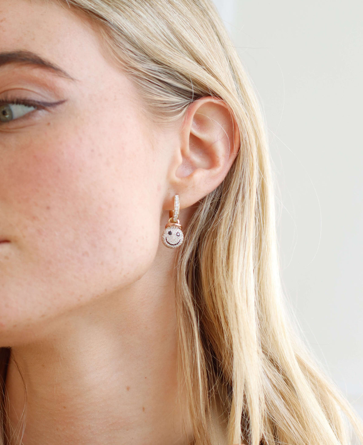 The Naughty or Nice Earrings from Janet Heller Fine Jewelry are crafted in 14KT gold.  The dangling earrings feature hoops with a smiley face in black and white diamonds. These playful earrings can be worn alone or layered along the ear with other earrings.