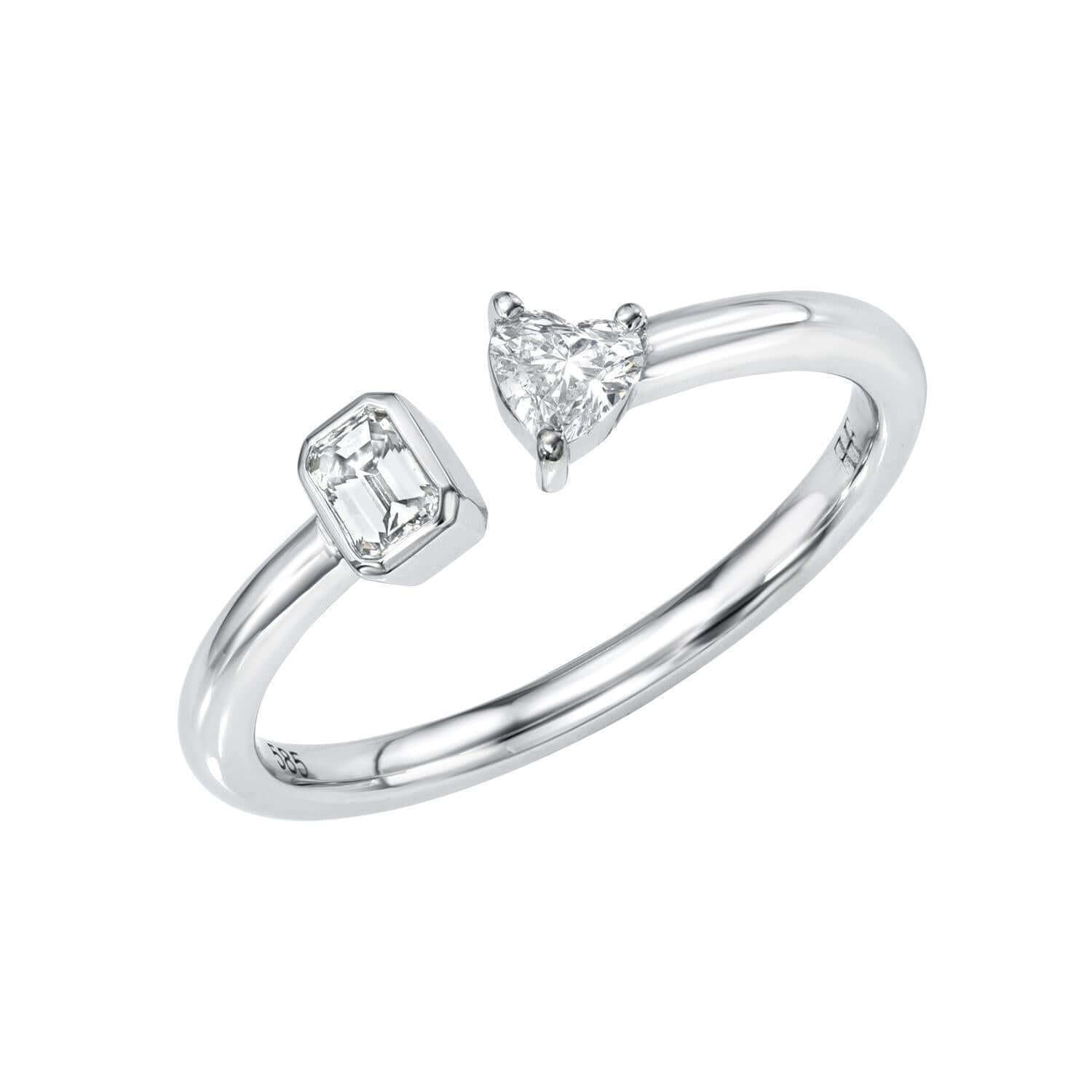 The Emerald & Heart Toi Et Moi Ring features an open silver band with an emerald-cut diamond on one end and a heart-shaped diamond on the other—ideal to symbolize love. Available for pre-order.