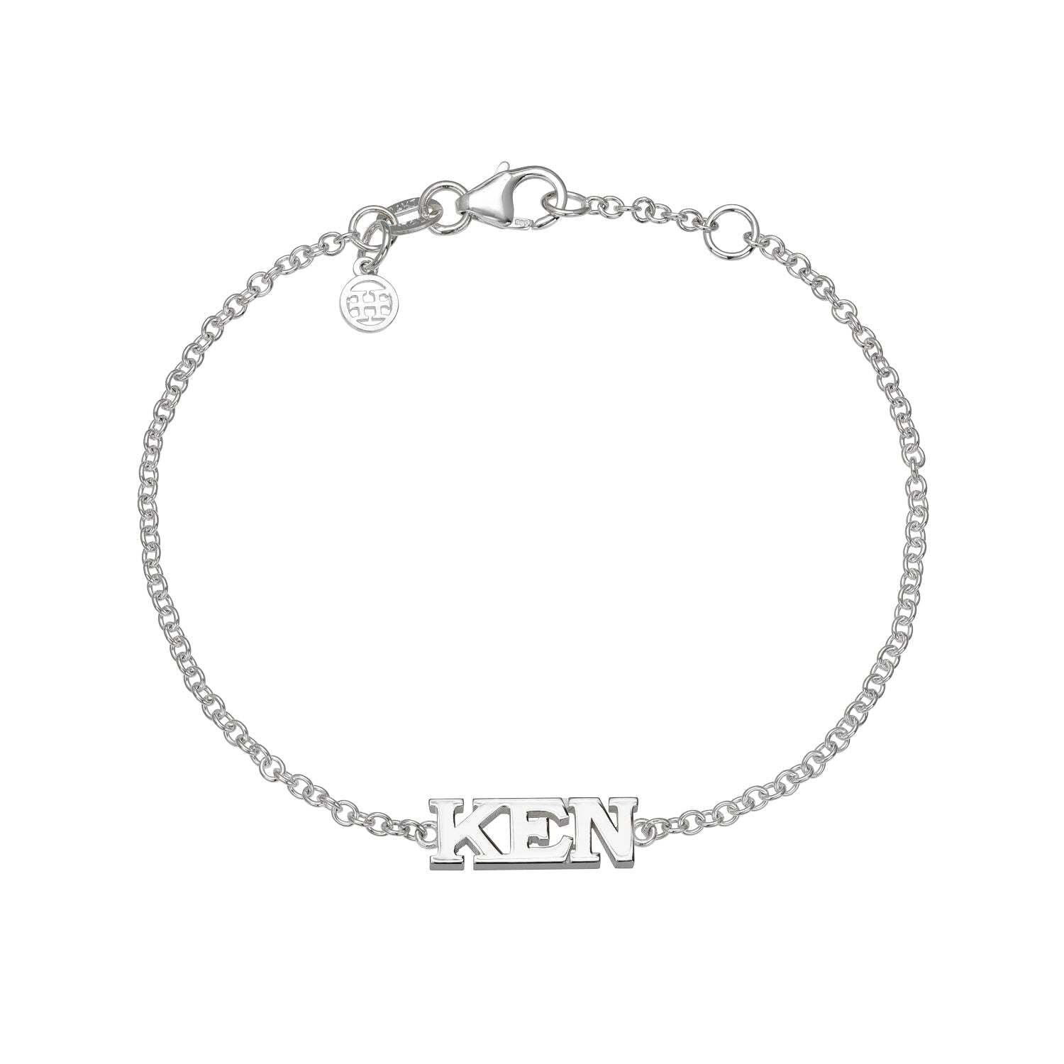Introducing the Block Name Bracelet—a silver chain bracelet featuring bold, capital letters spelling "KEN" as the central charm. This unique piece is finished with a secure lobster clasp and a small round tag near the closure, making it an ideal choice for anyone seeking standout or personalized jewelry to add to their collection.