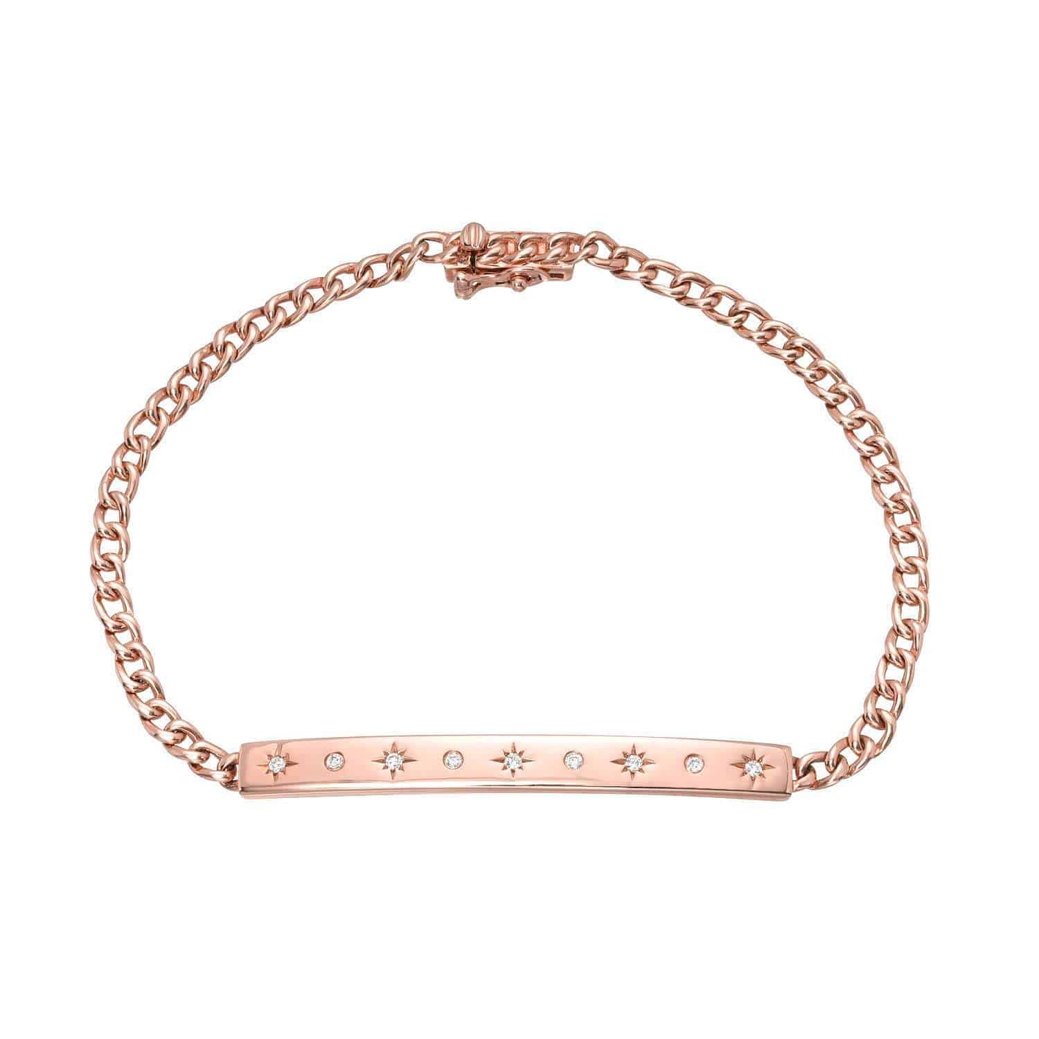 The Cuban Link Star Bar Bracelet from Janet Heller’s fine jewelry collection is a delicate rose gold chain bracelet featuring a flat bar adorned with seven small star-shaped designs, each set with a tiny clear stone at the center—a stunning piece of custom jewelry perfect for any occasion.