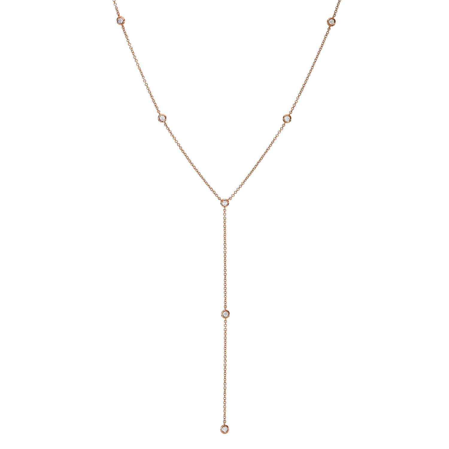 Diamond Logan Lariat: Exquisitely crafted by Janet Heller, this fine jewelry piece features a delicate Y-shaped design in gold, adorned with small round diamond accents evenly spaced along the chain and a vertical drop culminating in a single diamond. The Diamond Logan Lariat exudes simple elegance, presented beautifully against a white background. Price: $820.00.
