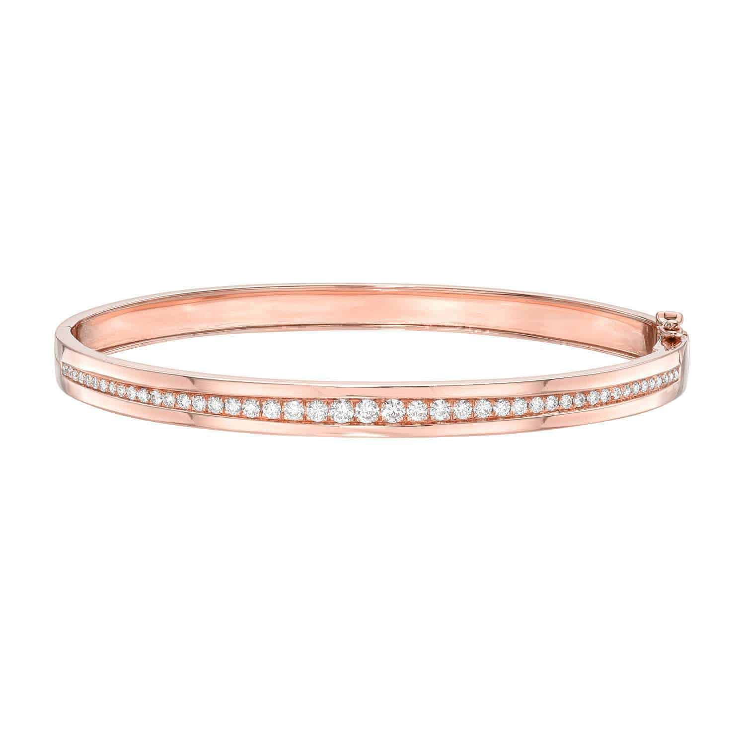 The Single Row Diamond Bangle from Janet Heller Fine Jewelry showcases a sleek rose gold design accented with a line of sparkling diamonds along the center, beautifully displayed on a white background—a testament to exceptional custom jewelry craftsmanship.