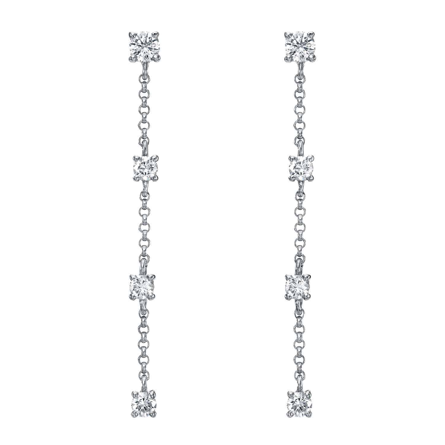 A pair of long, silver 4 Drop Diamond Finley Earrings showcases the elegance of fine jewelry, each featuring four evenly spaced round white gemstones set along the delicate chain for a stunning drop earring effect.