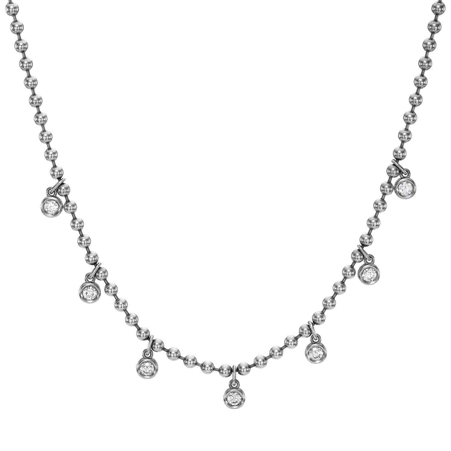 Introducing the Diamond Kinsley Necklace by Janet Heller Fine Jewelry—a stunning silver beaded necklace adorned with seven small round dangling pendants, each set with a brilliant diamond. These sparkling pendants are evenly spaced along the lower half of the chain, creating an elegant and timeless piece perfect for those who appreciate custom jewelry design.