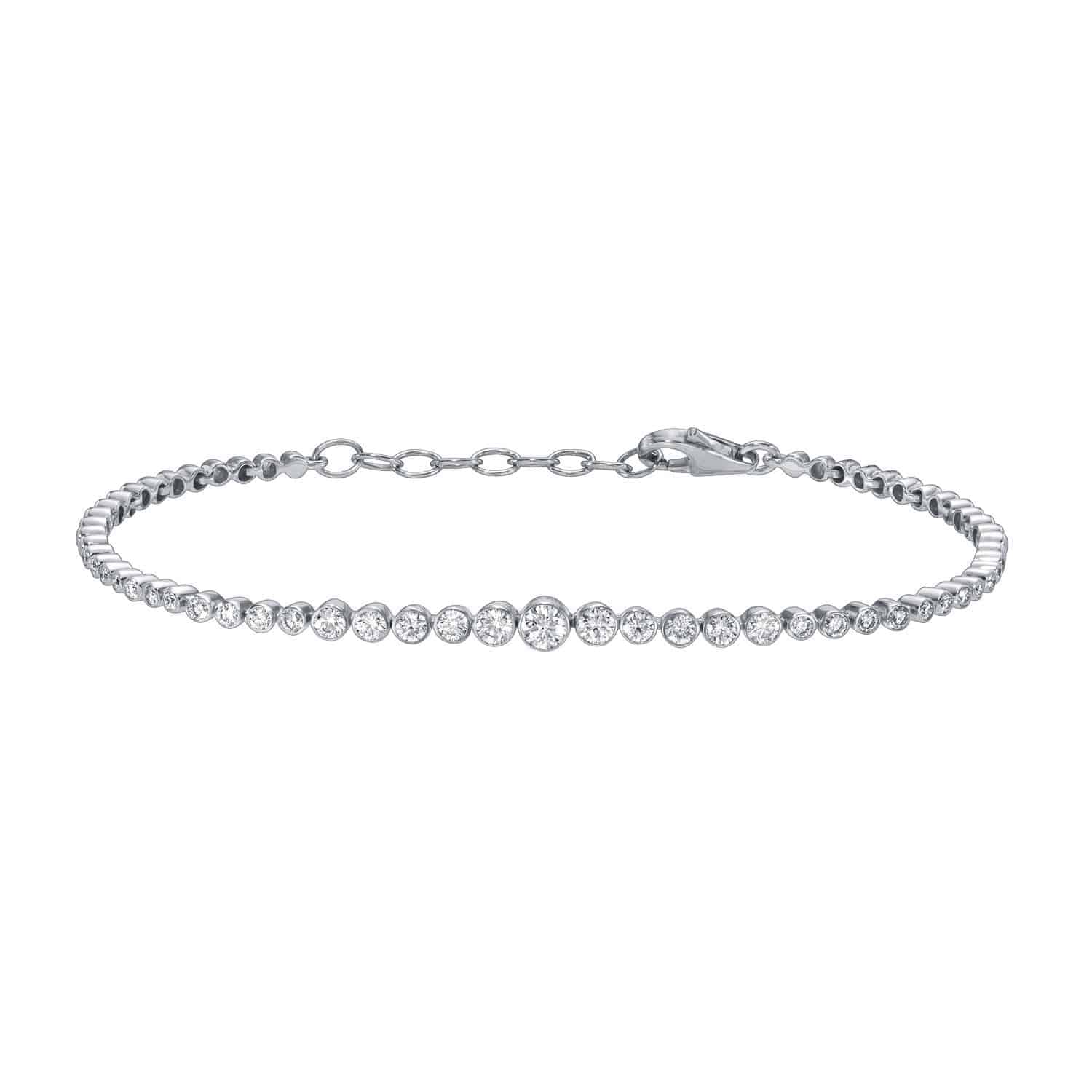 Introducing the Graduating Bezel Diamond Bracelet from Janet Heller Fine Jewelry—a delicate silver bracelet featuring a single row of round, clear diamonds set in graduating bezel settings. This elegant piece includes an adjustable chain and a secure lobster clasp closure. For jewelry inquiries or to explore custom options, please contact us.