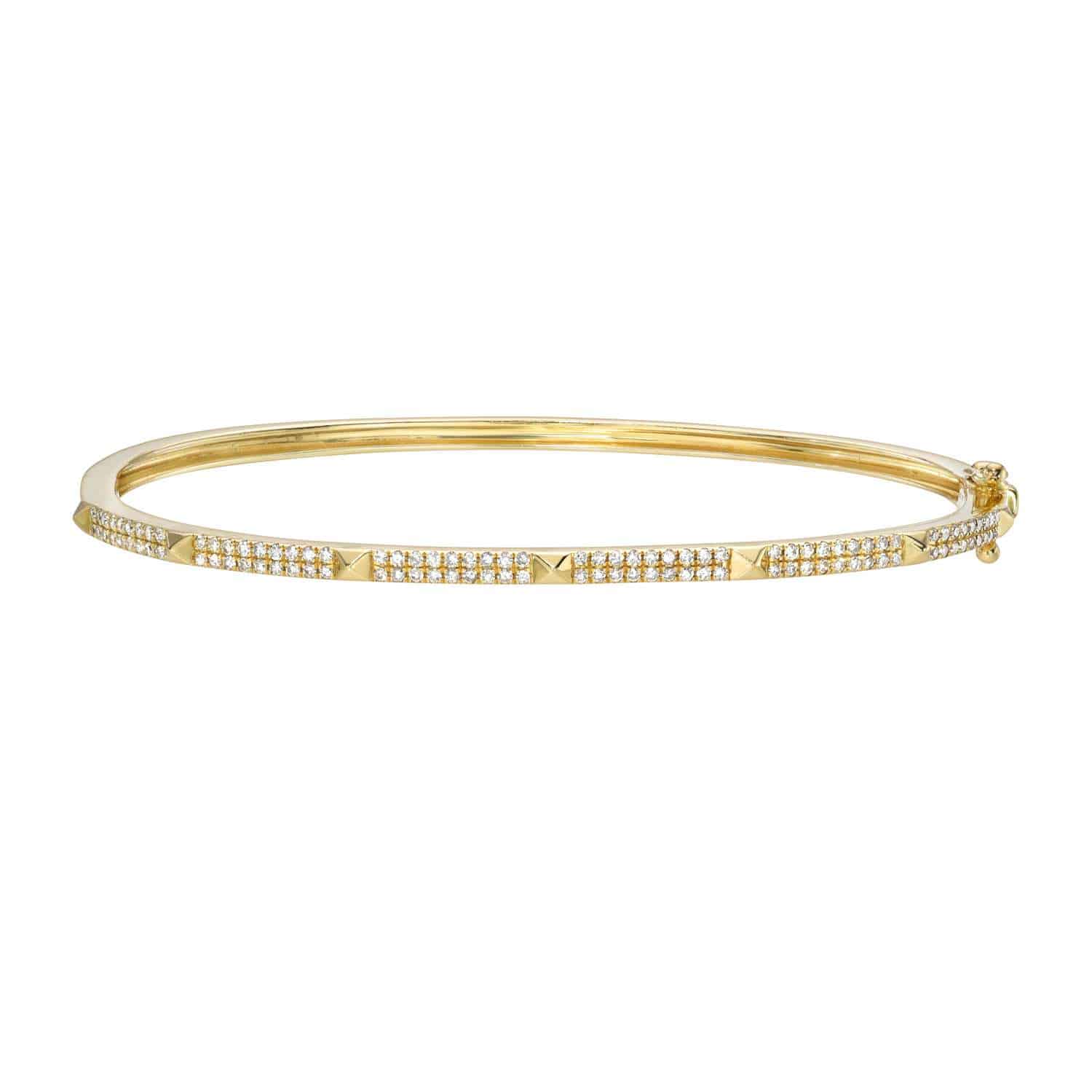 Introducing the Diamond Pyramid Olivia Bangle, a slim gold bracelet embellished with two rows of sparkling white diamonds and accented by evenly spaced gold pyramid-shaped studs along the top.