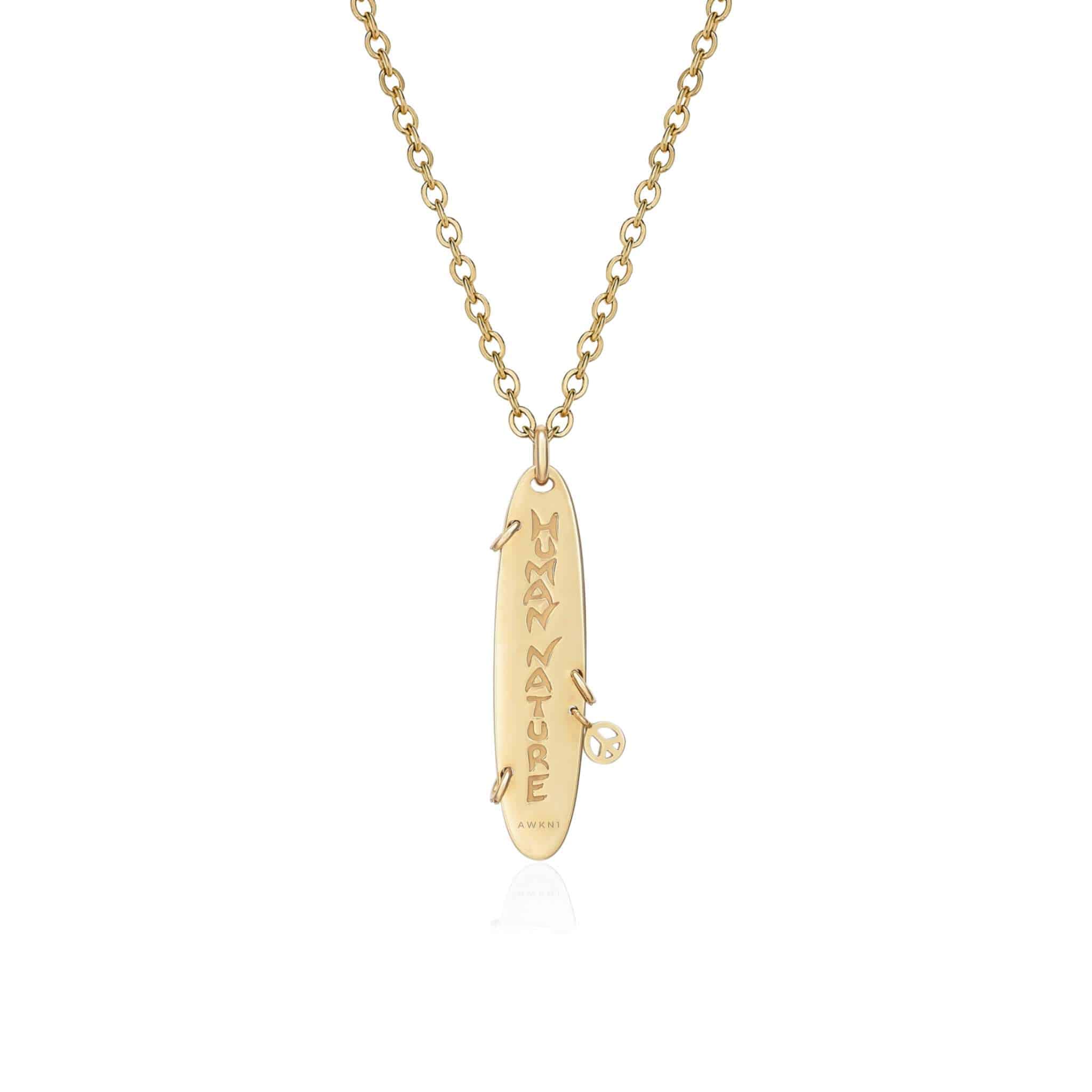 Diamond Loving Piercing Necklace featuring a gold chain with a vertical surfboard-shaped pendant engraved with IN MY NATURE and accented by a tiny diamond on the right side.