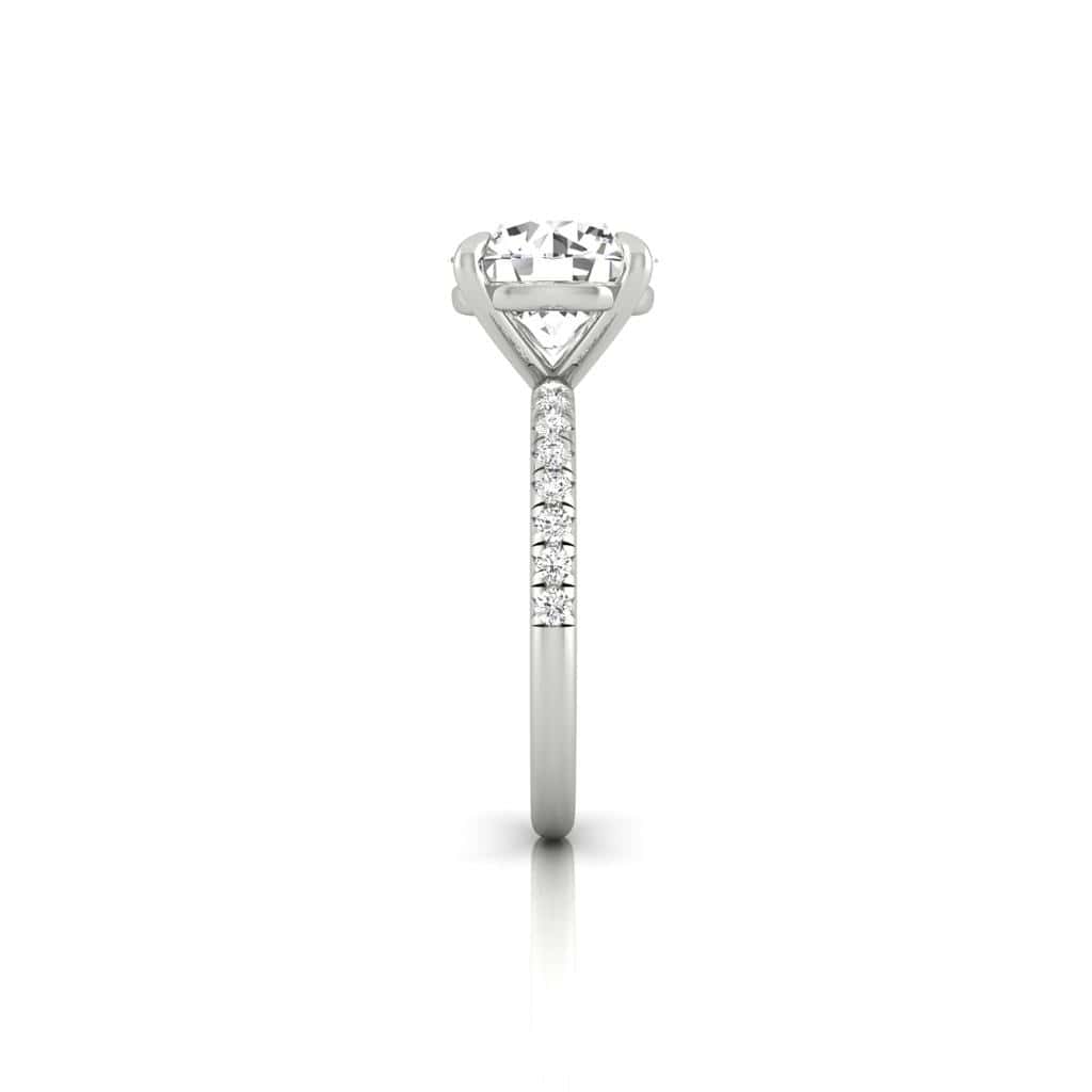 A side view of the Amélie engagement ring features a prong-set center diamond with a band adorned in a French Pavé style of small diamonds, all beautifully highlighted against a plain white background.